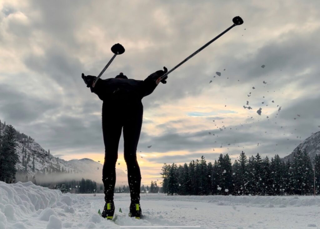 Cross-country skier gliding along a snow-covered Methow Trails path in winter