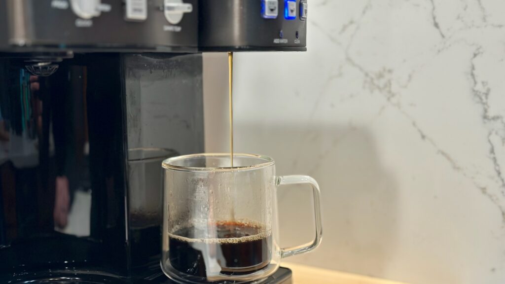 Luxury coffee maker at Pinehaven cabin filling a glass cup with steaming coffee