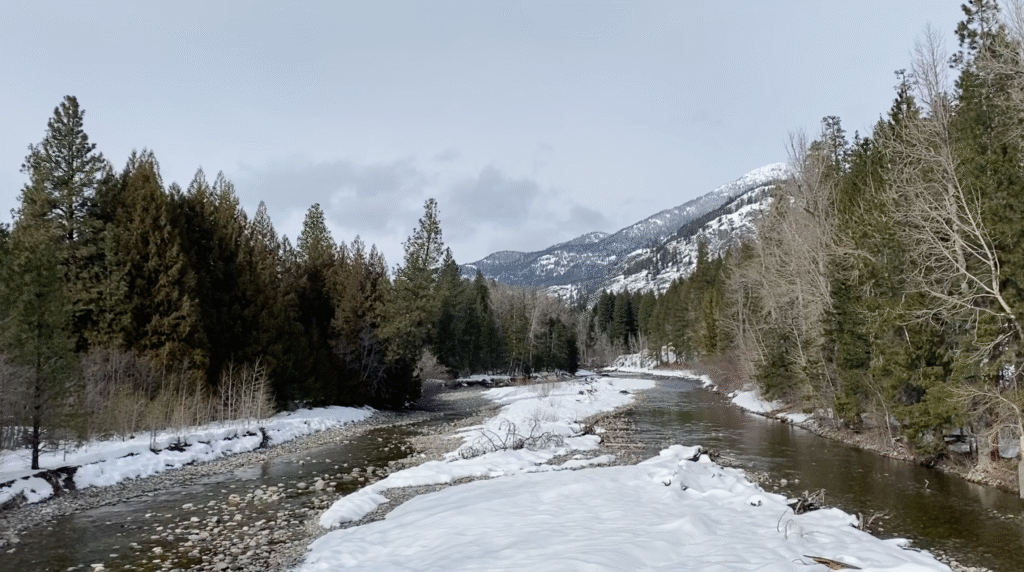 Snow-covered Methow River flowing under the suspension bridge in Winthrop, Washington