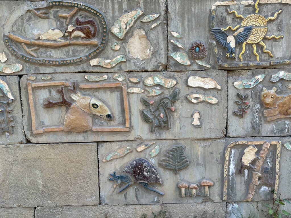Sculpted retaining wall featuring woodland creatures along the Methow Community Trail near the suspension bridge.