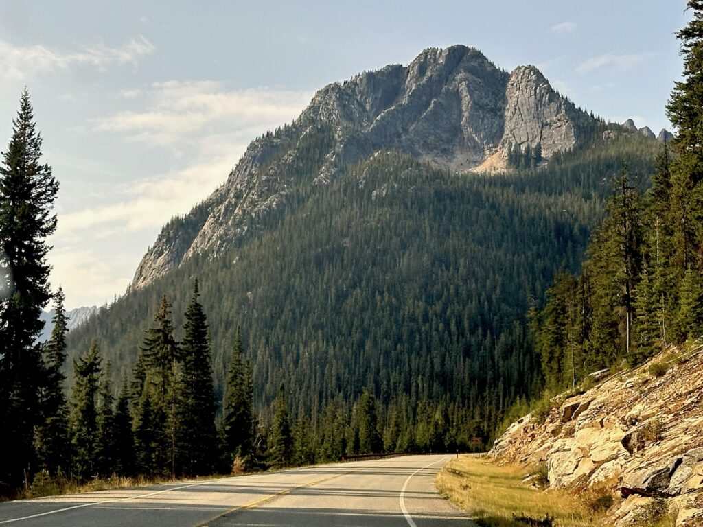 Afternoon sunlight shining over mountains and the scenic road through Washington Pass in the North Cascades, Washington.